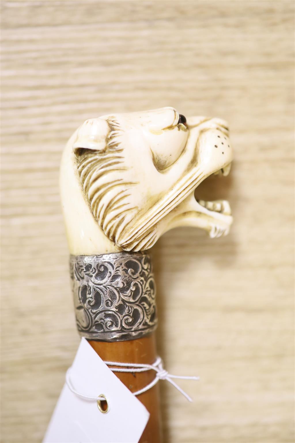 A Victorian sword cane, ivory lions head pommel with glass eyes, silver band H.M.Birmingham 1898, maker WS&ES, blade with traces